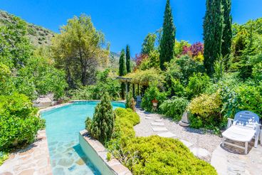 Holiday home with pool in front of a waterfall